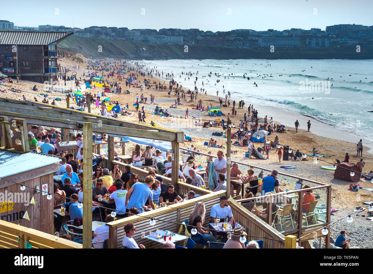 Holidaymakers enjoying the sunshine at a busy Fistral Beach in Newquay in Cornwall. Stock Photo
