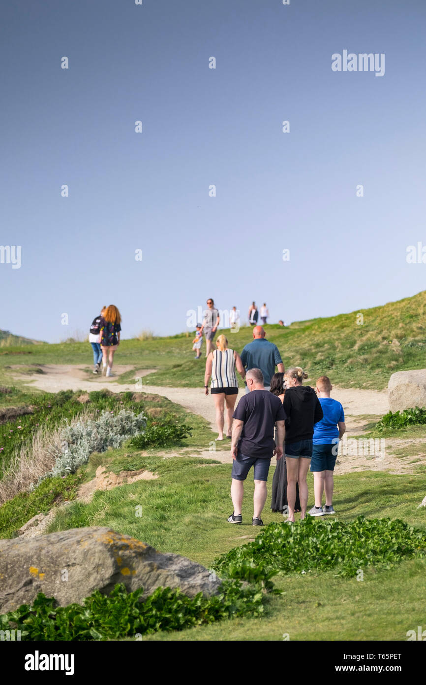 Holidaymakers enjoying a walk over the Headland on the coast in Newquay in Cornwall. Stock Photo