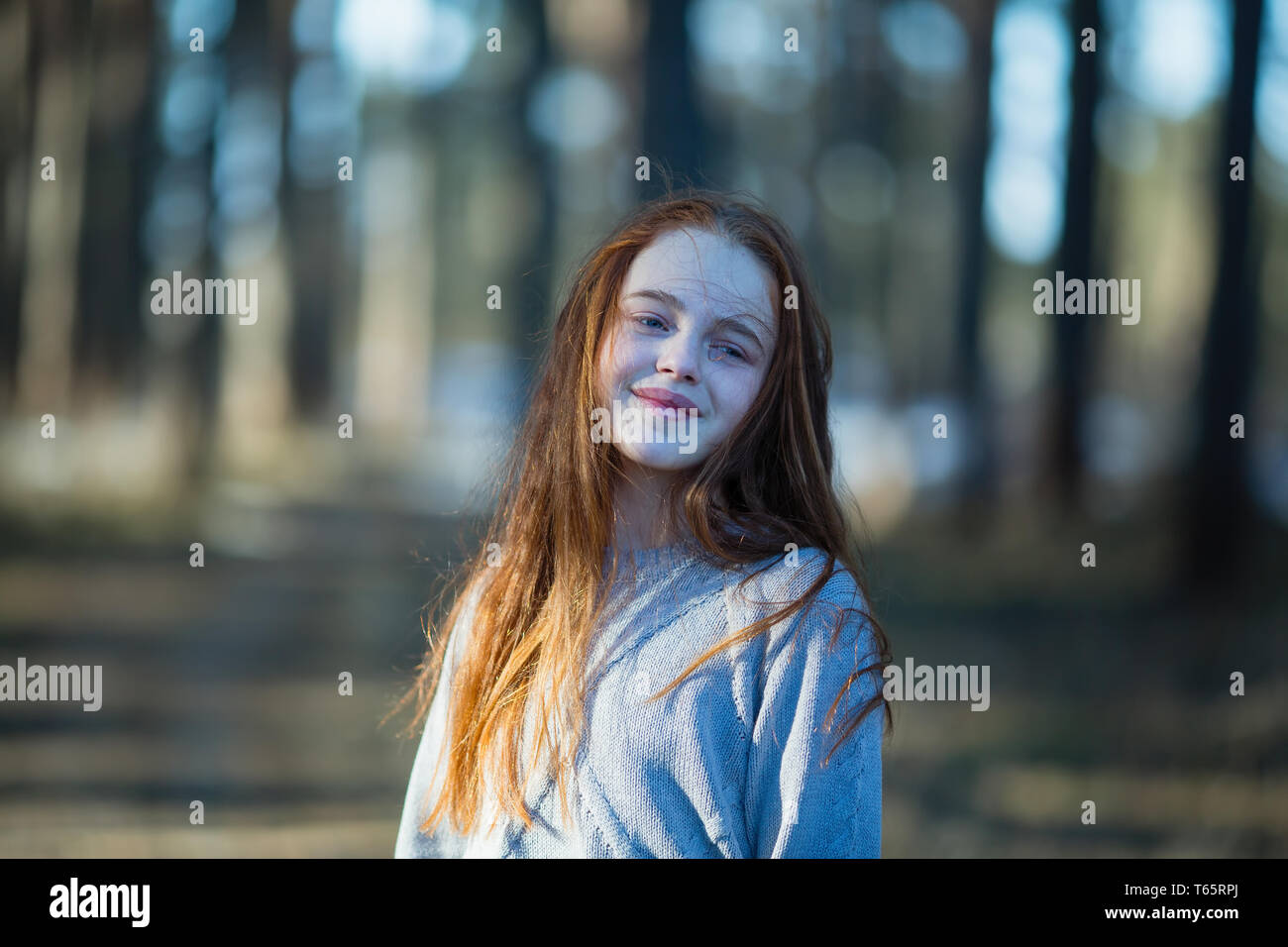 Twelve-year-old cute girl with long red hair posing for the camera in ...