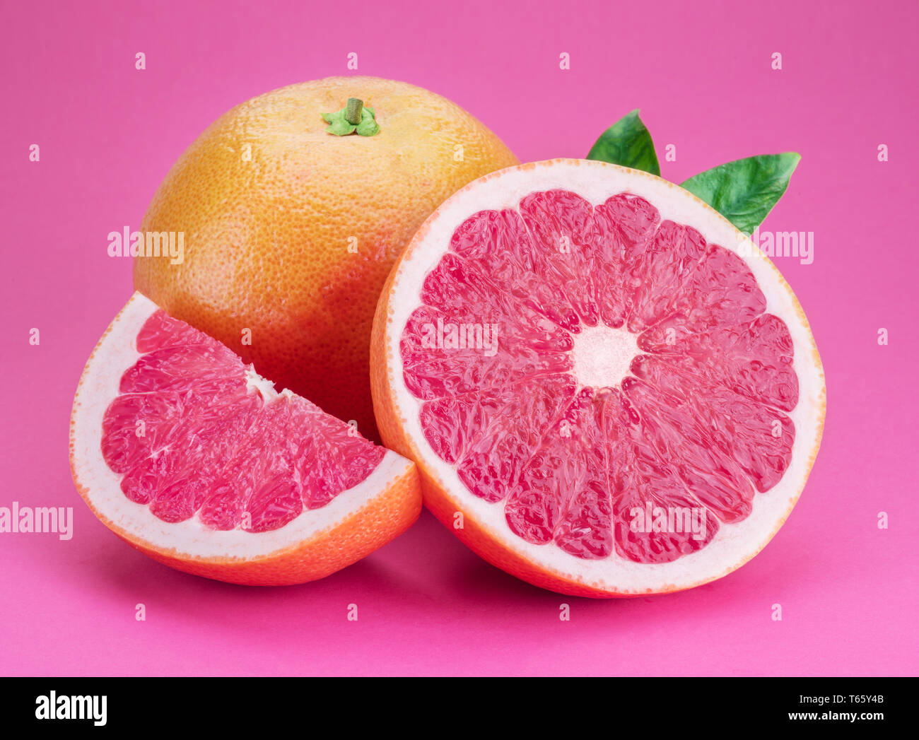 Grapefruit and grapefruit slices isolated on pink background. Stock Photo