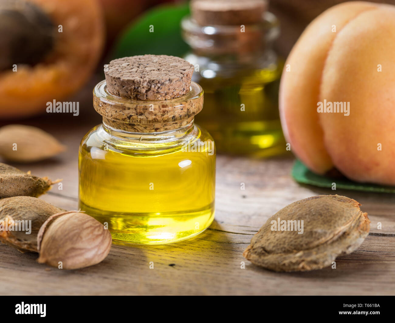 Apricot kernel oil and apricot kernels on wooden background. Stock Photo by  ©Valentyn_Volkov 274249384