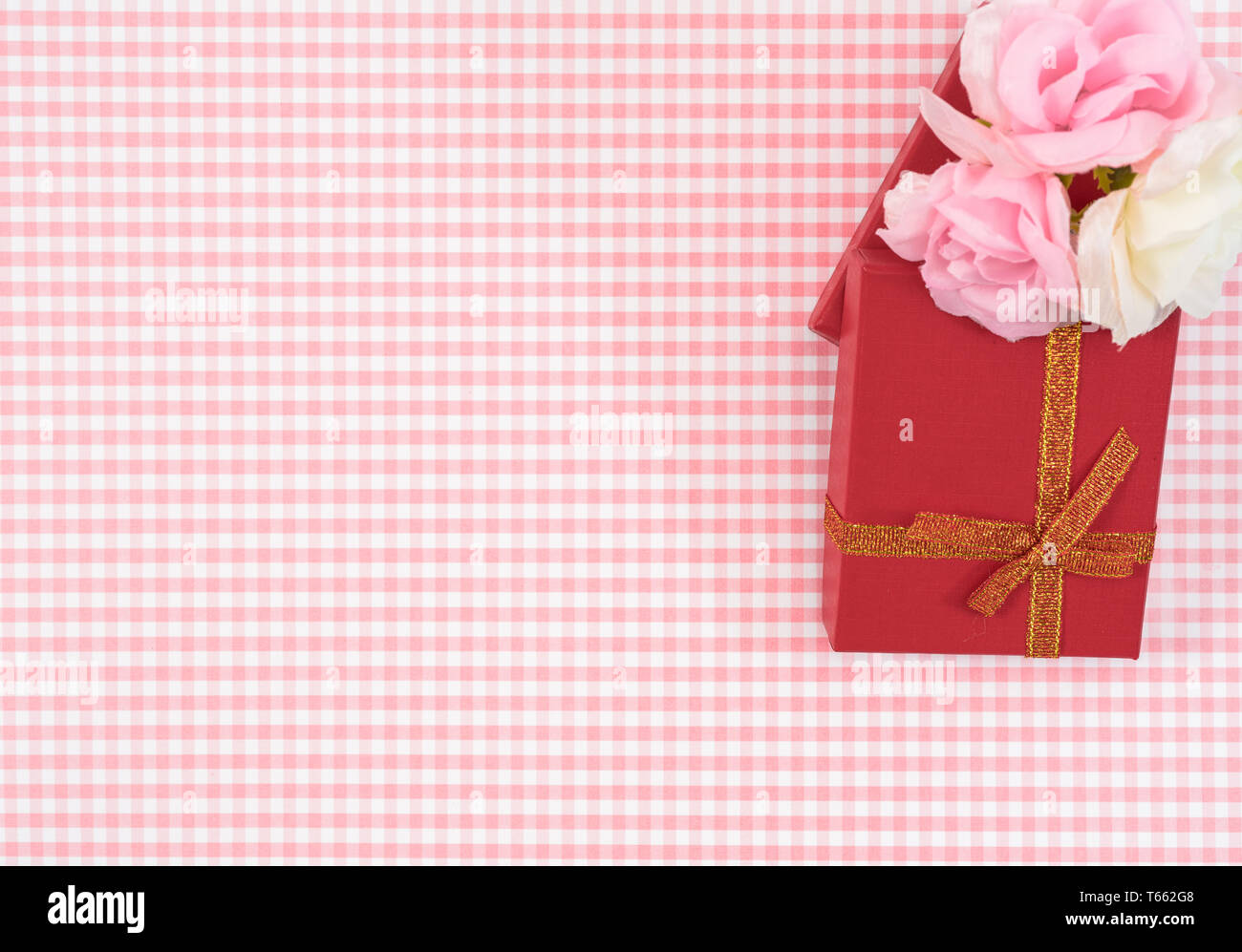 gift box with red isolated on Plaid background. Holiday decoration for Mother's Day or Women's Day. Stock Photo