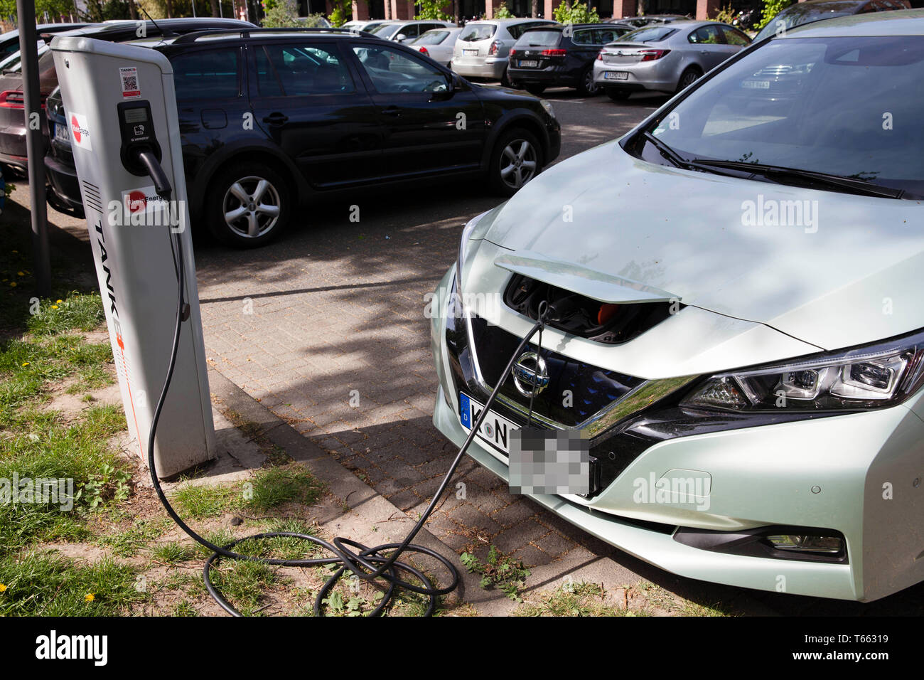 a Nissan Leaf at a charging station of the Mobilstation on the Charles-de-Gaulle square in the district Deutz, Cologne, Germany. With a direct connect Stock Photo