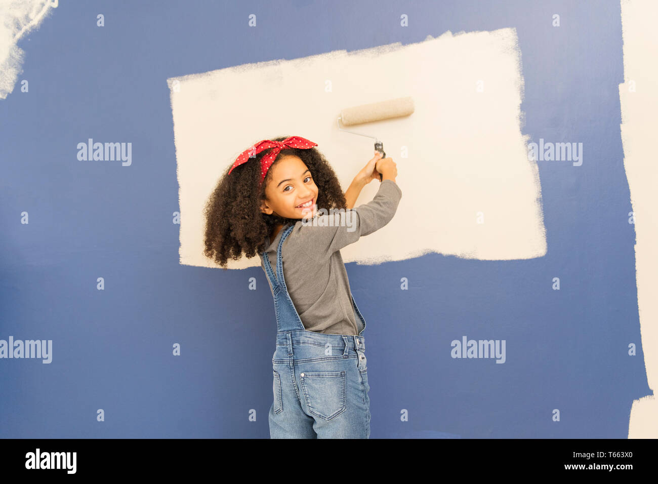 Portrait happy, confident girl painting wall Stock Photo