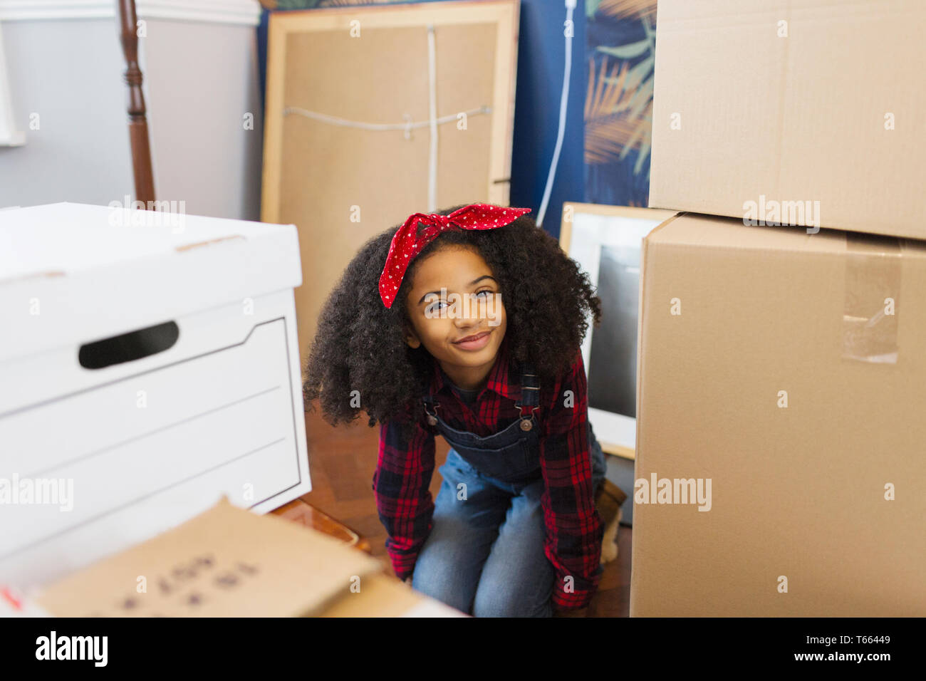 Portrait happy, cute girl among moving boxes Stock Photo
