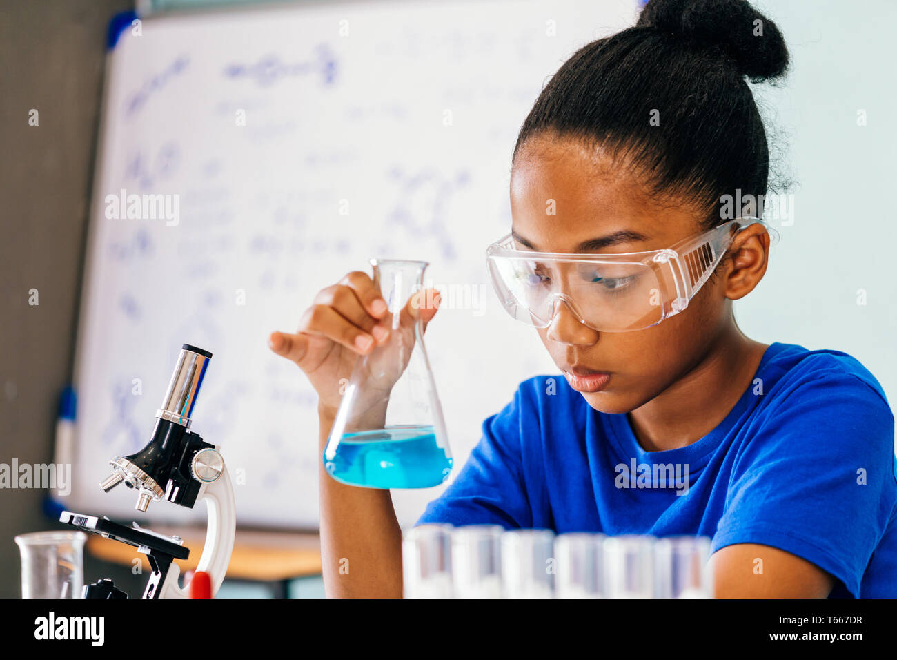 Young African American Mixed Kid Testing Chemistry Lab Experiment And Shaking Glass Tube Flask Along With Young African American Mixed Kid Testing Chemistry Lab Experiment And Shaking Glass Tube Flask Along With