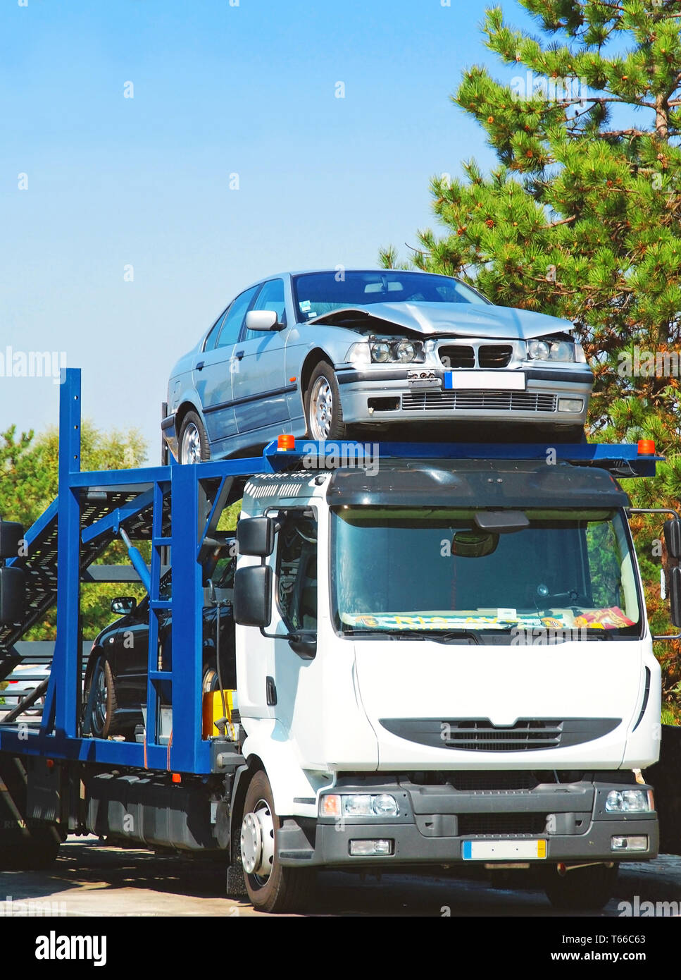 Truck carrying a car after a road accident Stock Photo