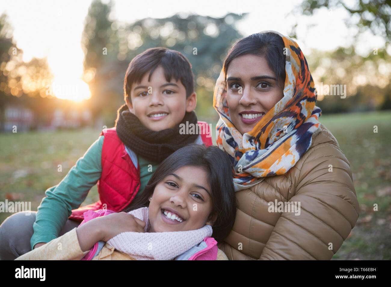 Portrait happy Muslim mother in hijab with children in autumn park Stock Photo