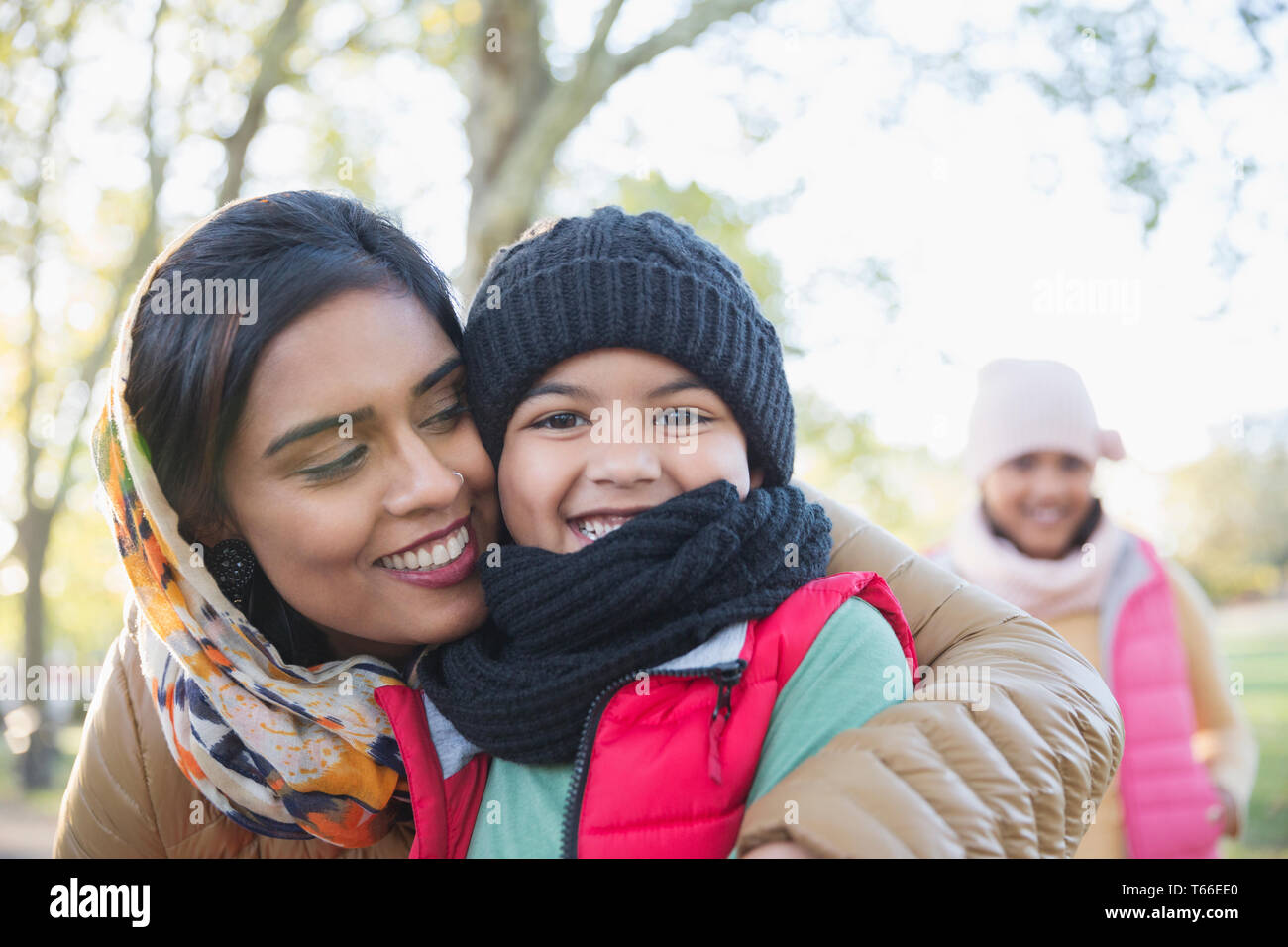 Portrait happy Muslim mother in hijab hugging son in autumn park Stock Photo