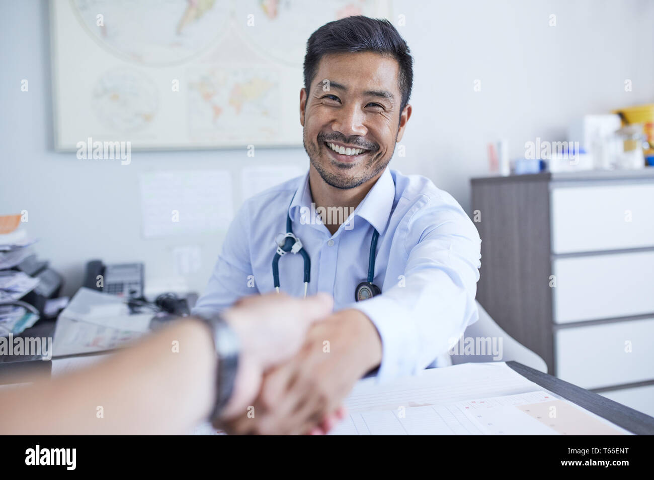 Point of view happy doctor shaking hands with patient Stock Photo