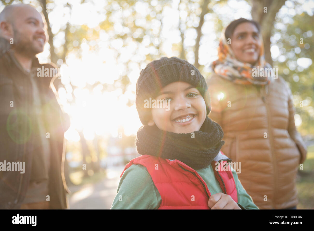 Portrait happy boy with parents in sunny autumn park Stock Photo