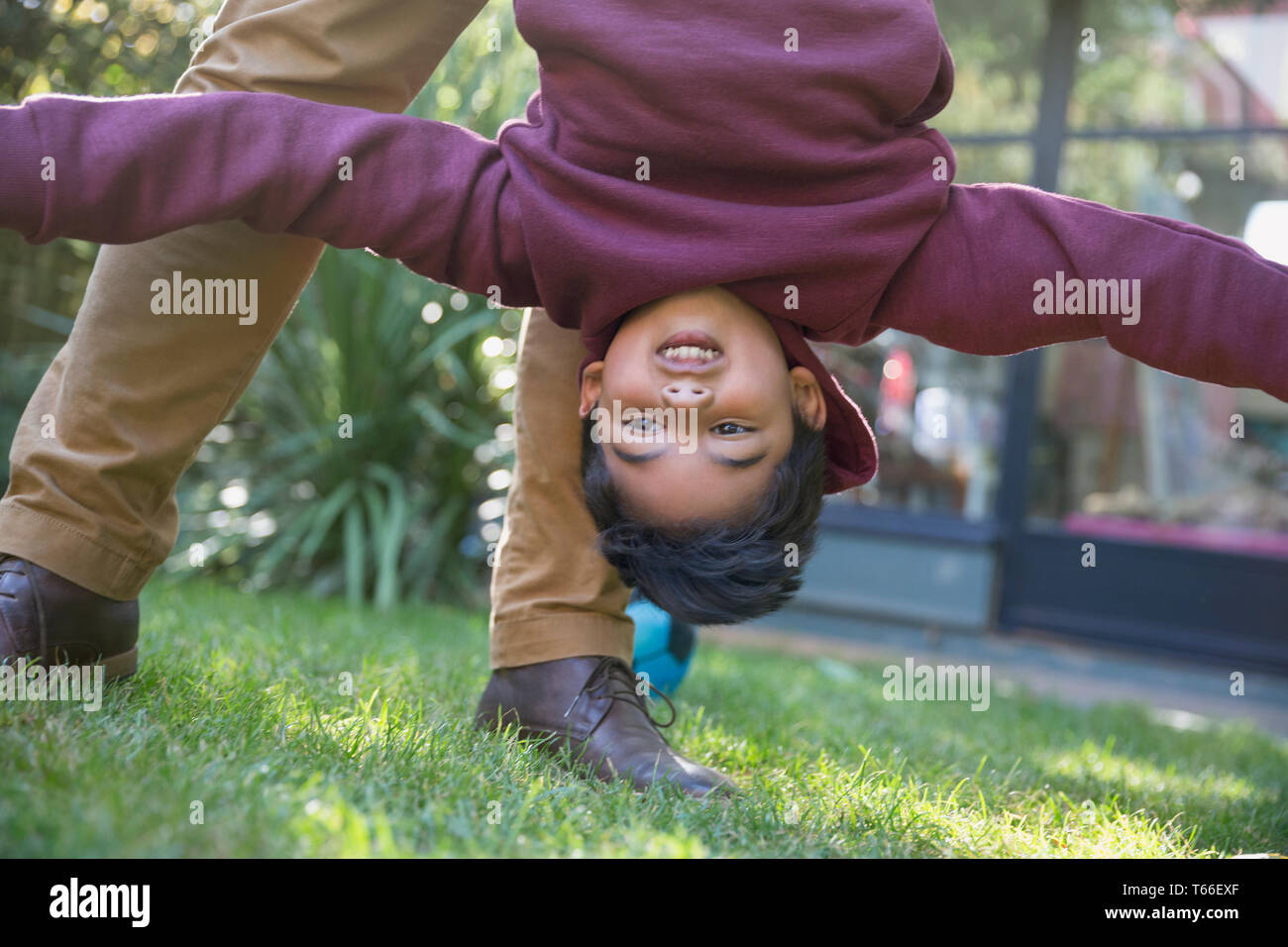 Playful boy hanging upside down Stock Photo