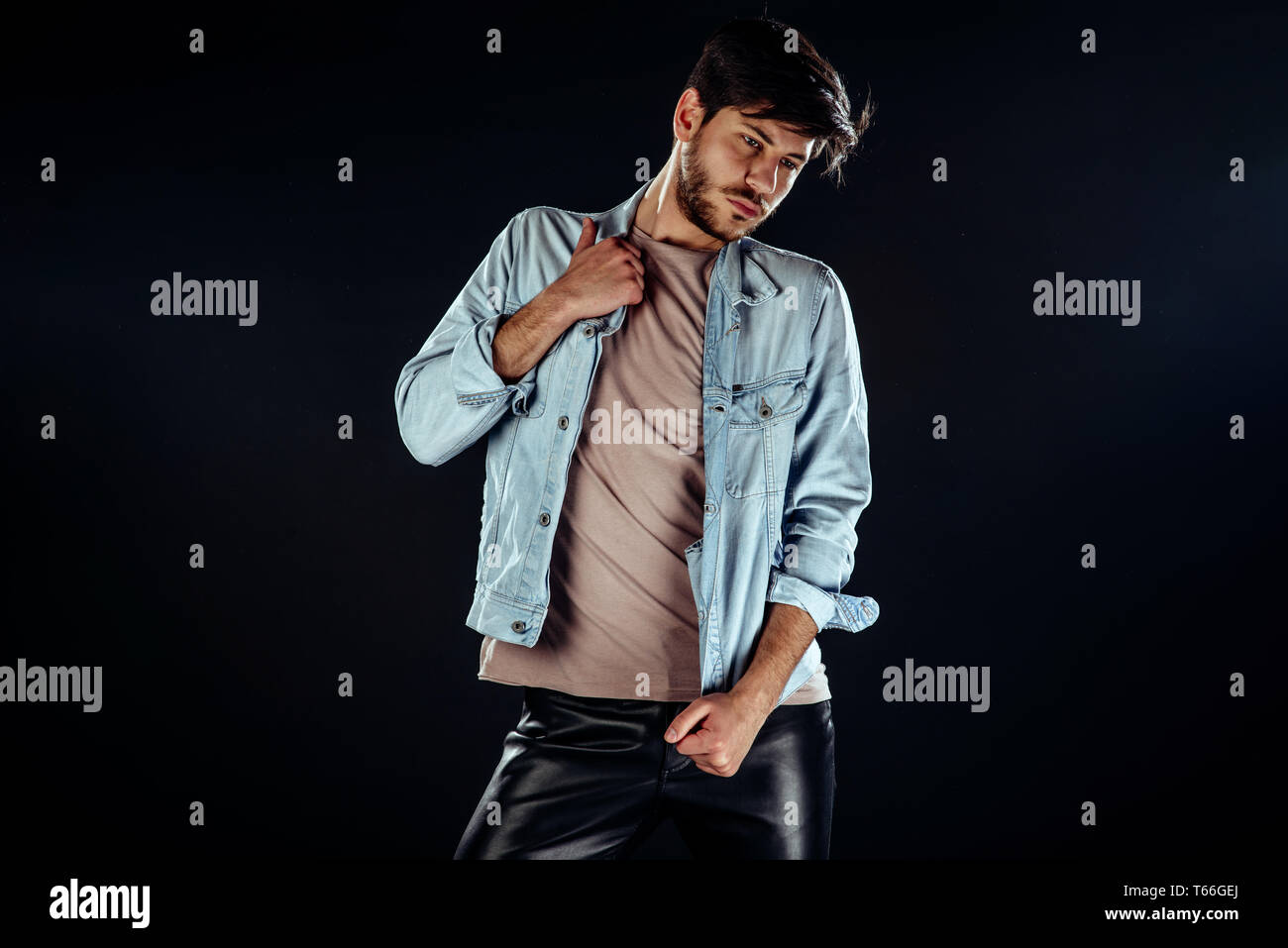 A potrait of a charming young man while posing in modern studio Stock ...
