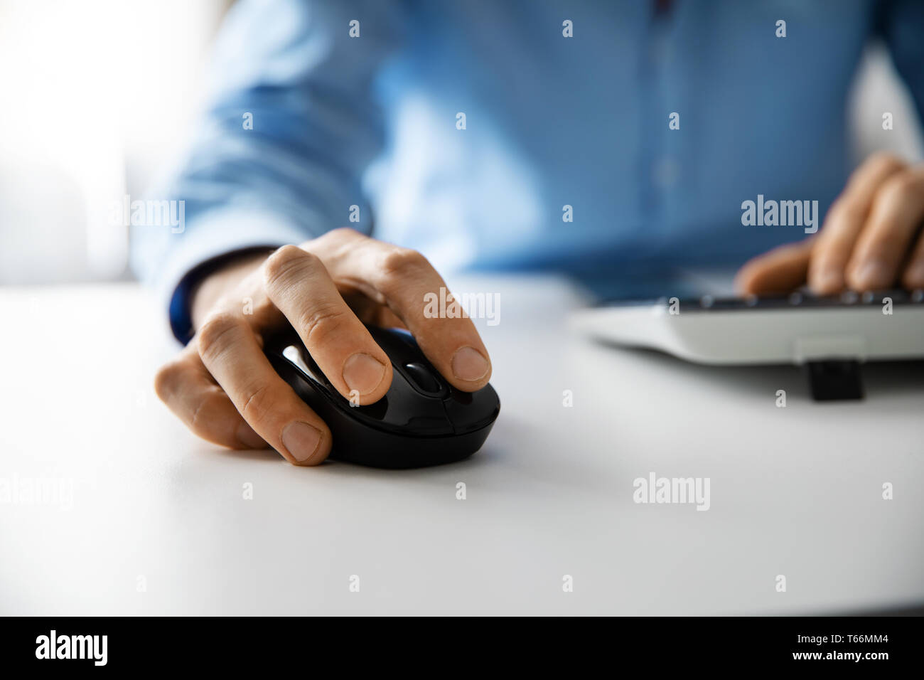 white collar work - man working with desktop computer in office closeup of hand clicking mouse Stock Photo