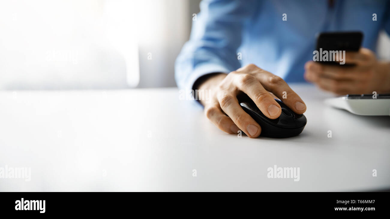 man working with desktop computer and using smart phone in office. copy space Stock Photo