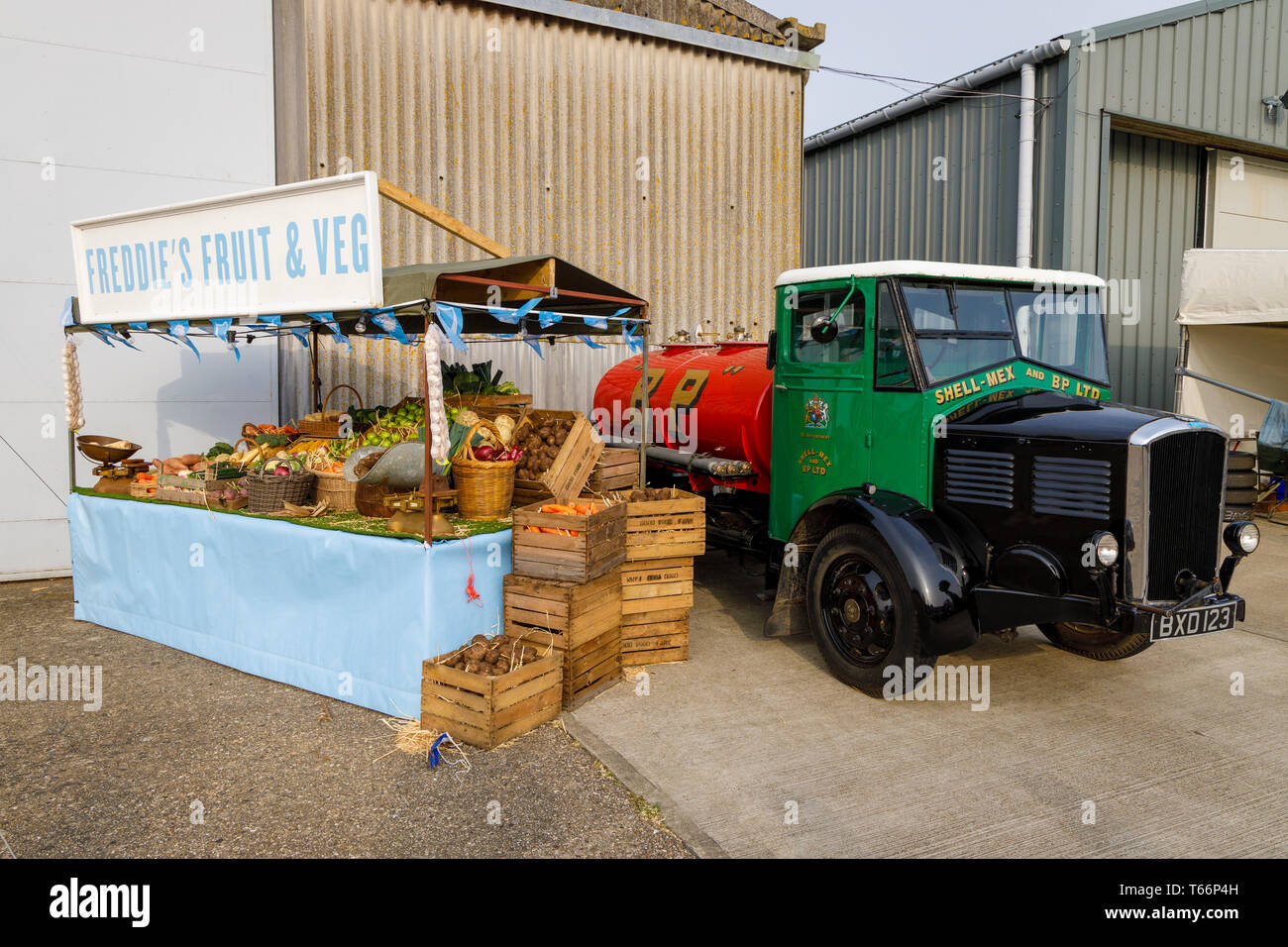 1935 Dennis Shell-Mex and BP fuel tanker beside a traditional fruit and veg' stall at the 77th Goodwood GRRC Members Meeting, Sussex, UK. Stock Photo