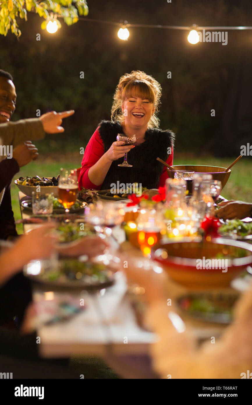 Happy woman laughing, enjoying dinner garden party with friends Stock Photo