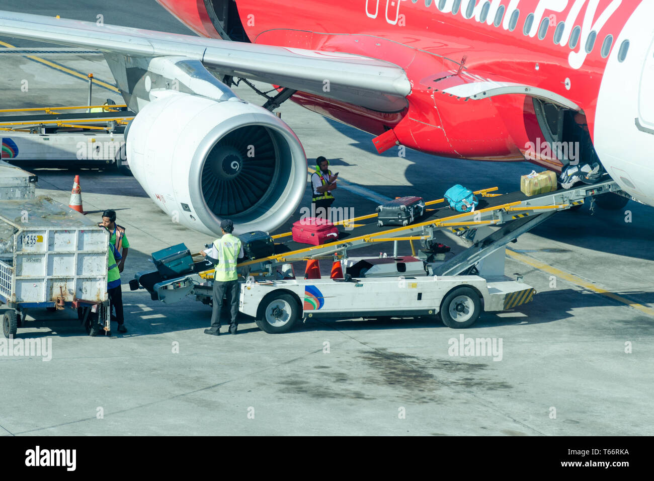 Bali, Denpasar, 2018-05-01: Airport luggage workers loading bags into airplane. Travel and industry concepts. Stock Photo