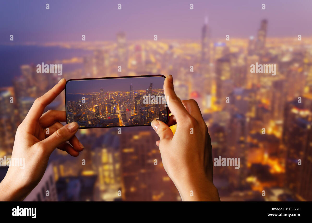 Hands hold telephone taking photo of Chicago USA panorama at night Stock Photo