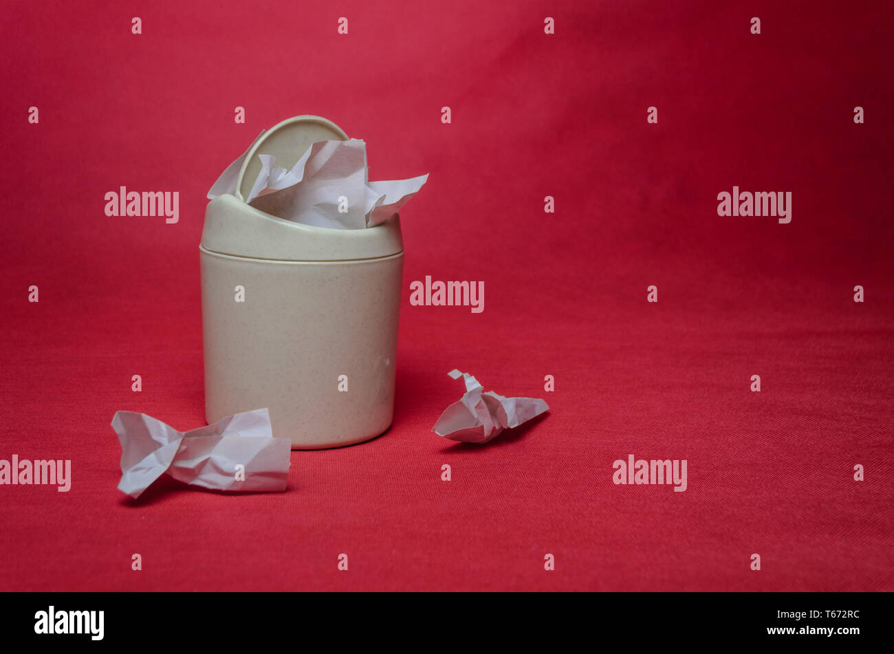 Light trash bin on a red background. Closeup of crumpled sheets of ...