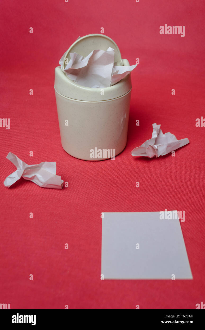 Light trash bin on a red background. Closeup of crumpled sheets of ...