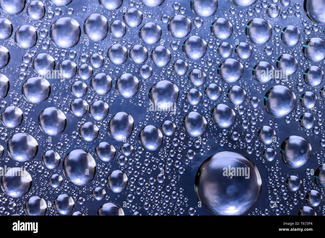 Metallic blue colored wet rainy background, water drops on transparent glass Stock Photo