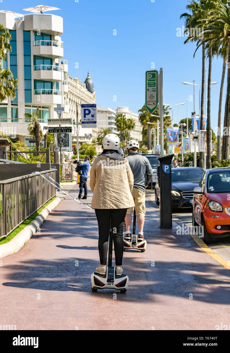 CANNES, FRANCE - APRIL 2019: Person riding a Segway auto balancing vehicle on a pavement on the seafront in Cannes. Stock Photo