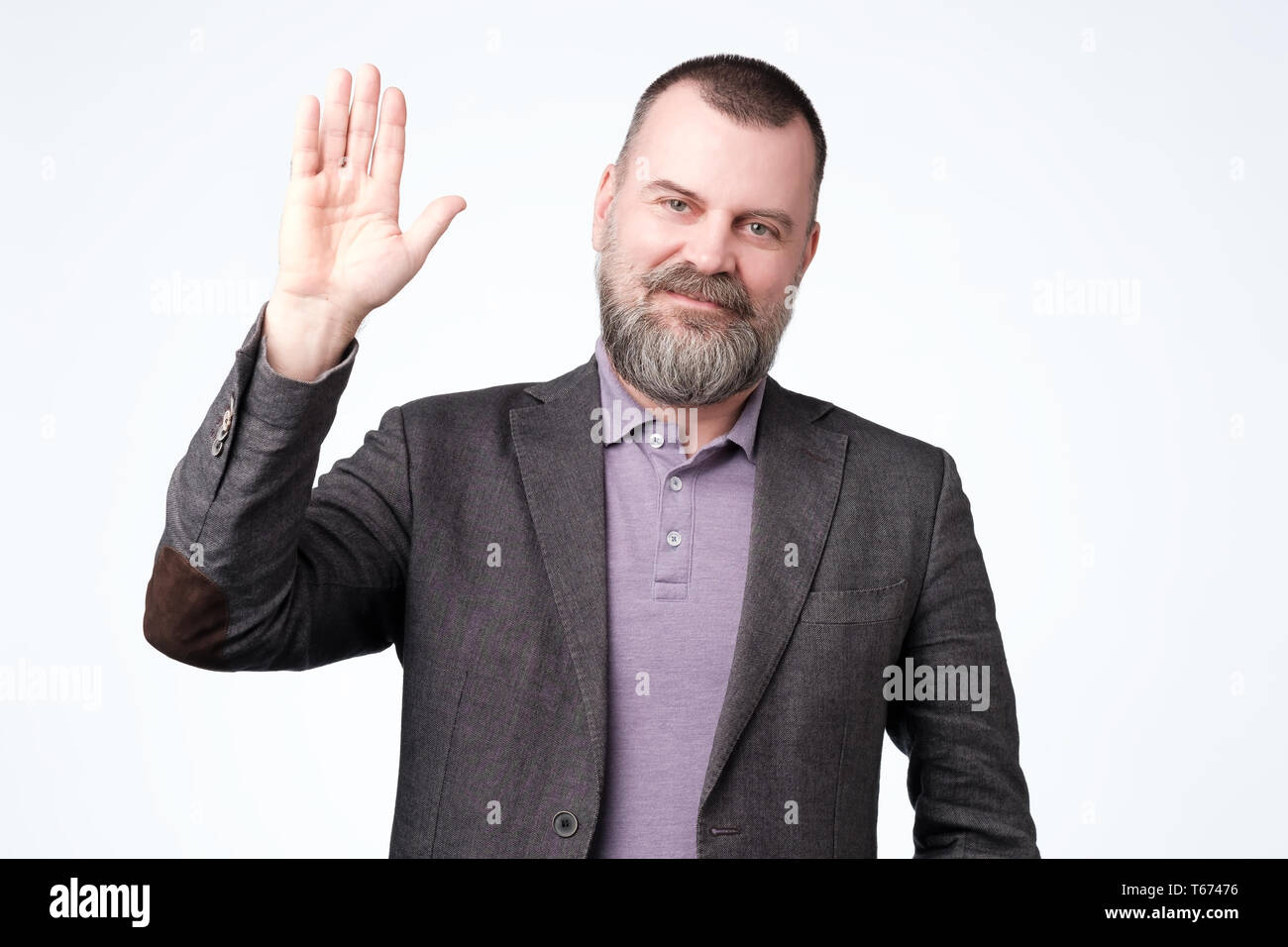 Mature man in jacket wave hand welcome. Stock Photo
