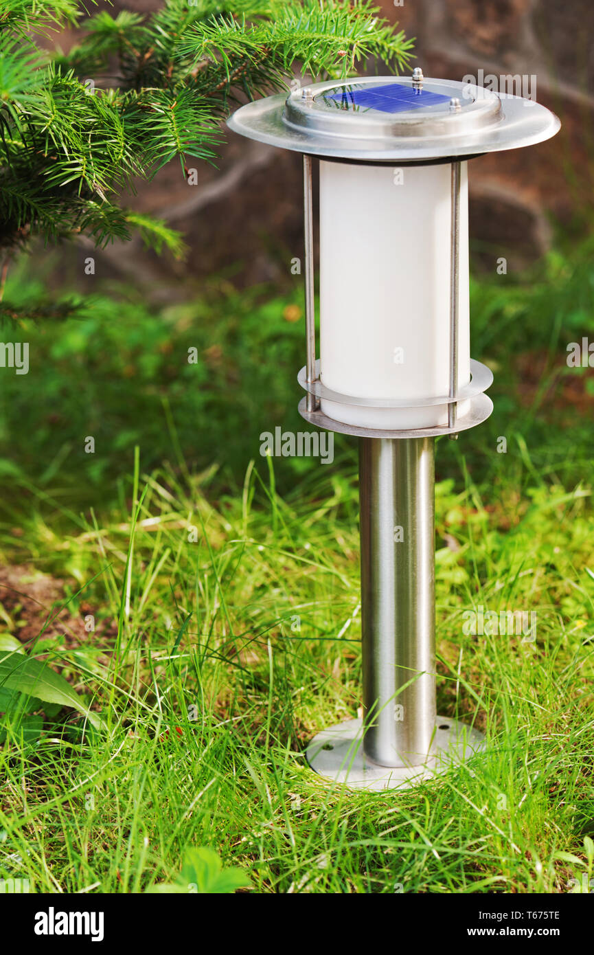 Solar-powered lamp on garden background. Selective Stock Photo