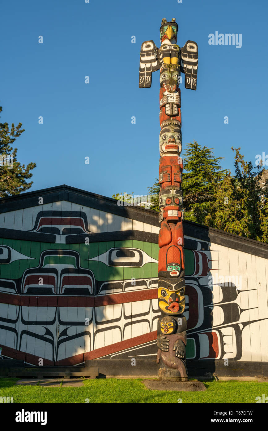 A totem pole and the Mungo Martin House in Thunderbird Park in Victoria, British Columbia, Canada. Stock Photo