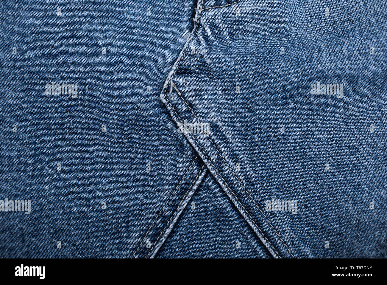 Denim jeans texture background with torn. The texture of the colored cotton fabric. Stitched texture jeans background. Pocket and rivet on jeans. Fibe Stock Photo