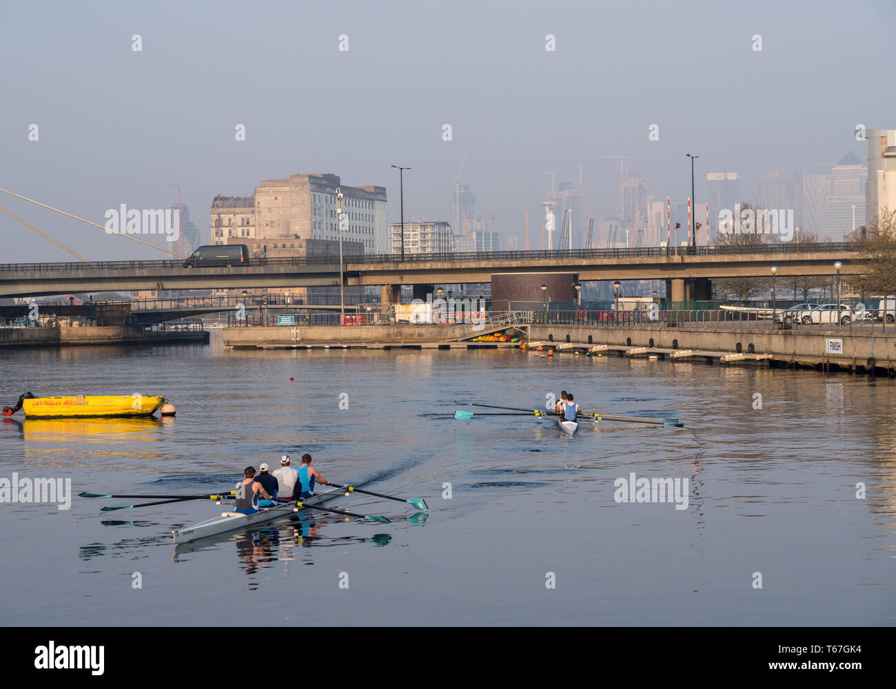 Rowers by London City Airport at sunrise on misty day Stock Photo