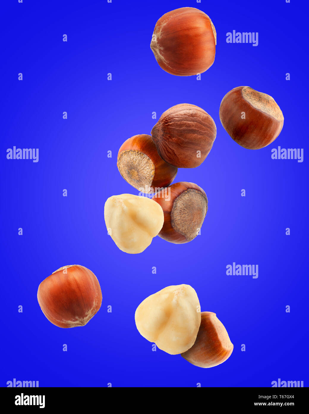 Falling hazelnuts on color background Stock Photo