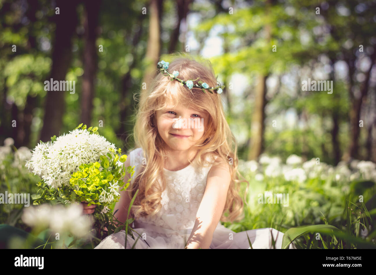 Beautiful Blond Girl Princess Sitting In Green Spring Meadow With White Flowers In Hand Pastel Colors Stock Photo Alamy