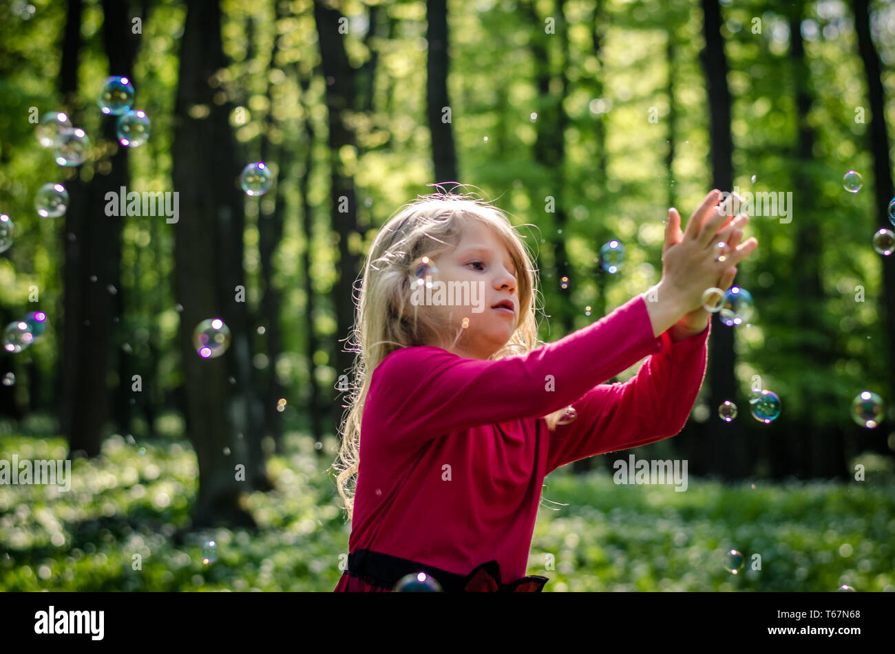 adorable little girl playing in spring forest Stock Photo - Alamy