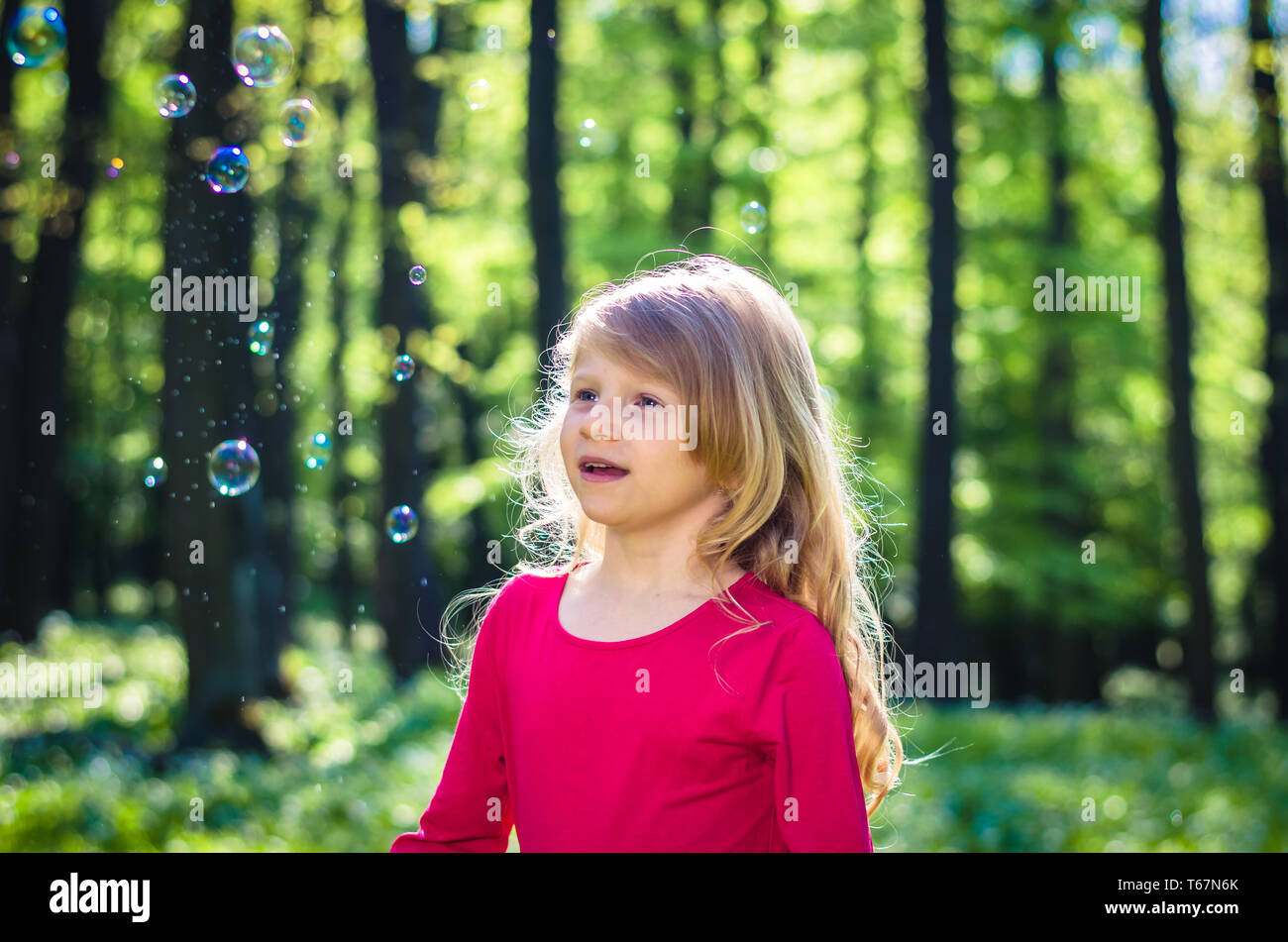 adorable little girl playing in spring forest Stock Photo - Alamy