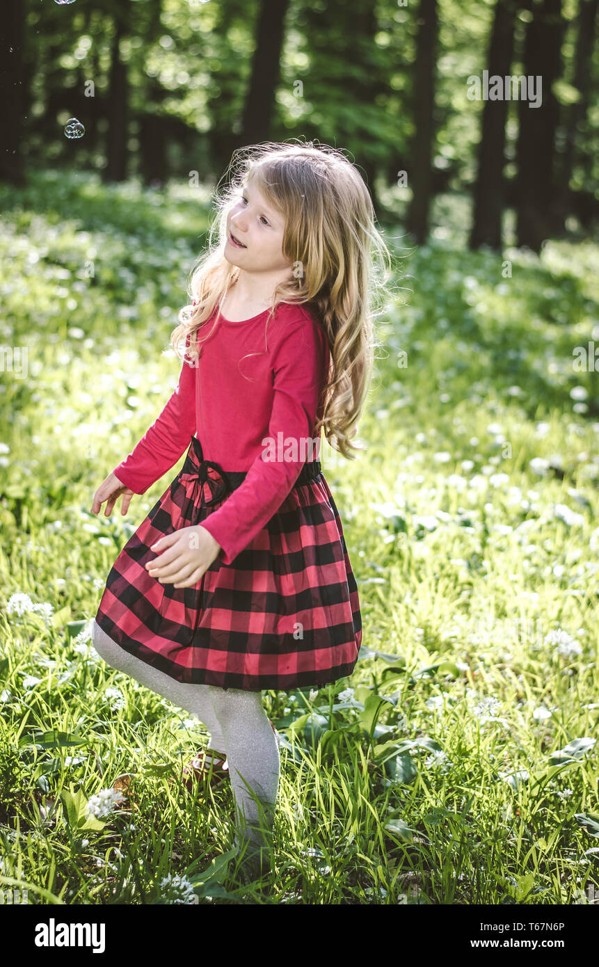 adorable little girl playing in spring forest Stock Photo - Alamy