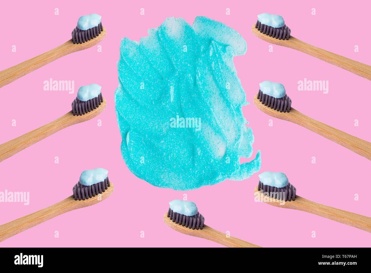 Frame of bamboo toothbrushes with blue toothpaste isolated on pink ...