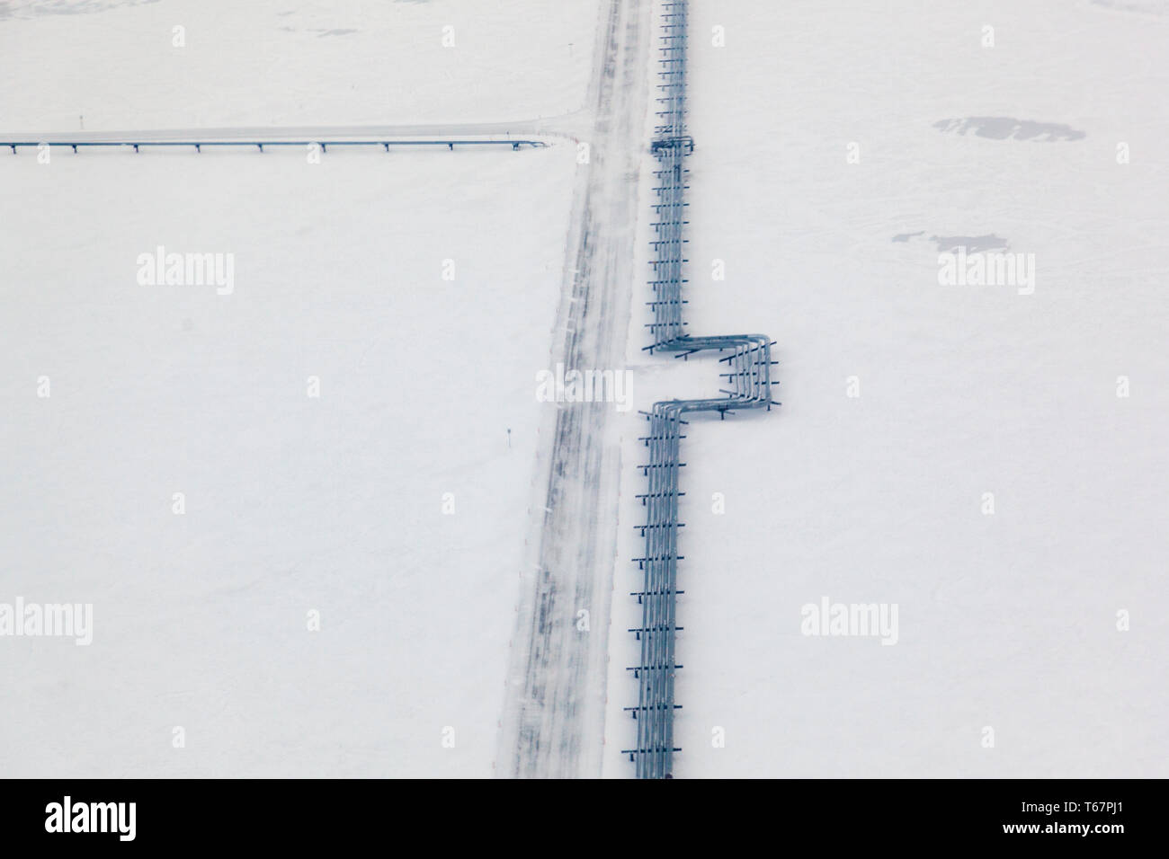 Oil pipeline and iceroad leading from the ConocoPhillips oilwells in Alpine, connecting to the Pump station 1 on the Alyeska Pipeline in Prudhoe Bay, the northern start of the Trans-Alaska Pipeline System. Stock Photo