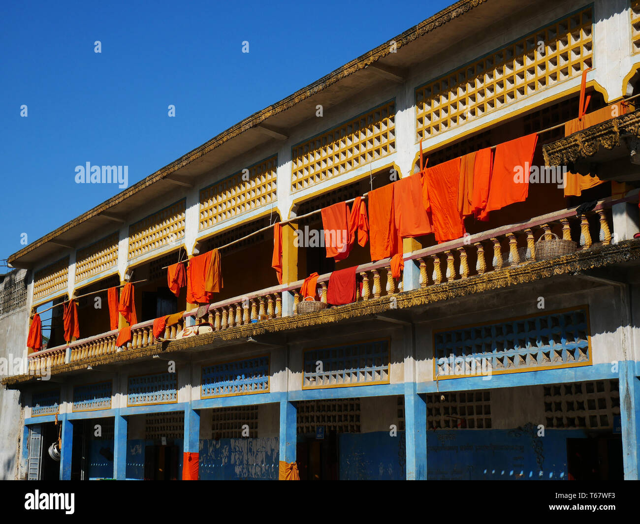 Saffron coloured Buddhist robes hanging inside the old walled temple of Entri Sam Voreak Pagoda. Kampong Thom, Cambodia. 19-12-2018 Stock Photo