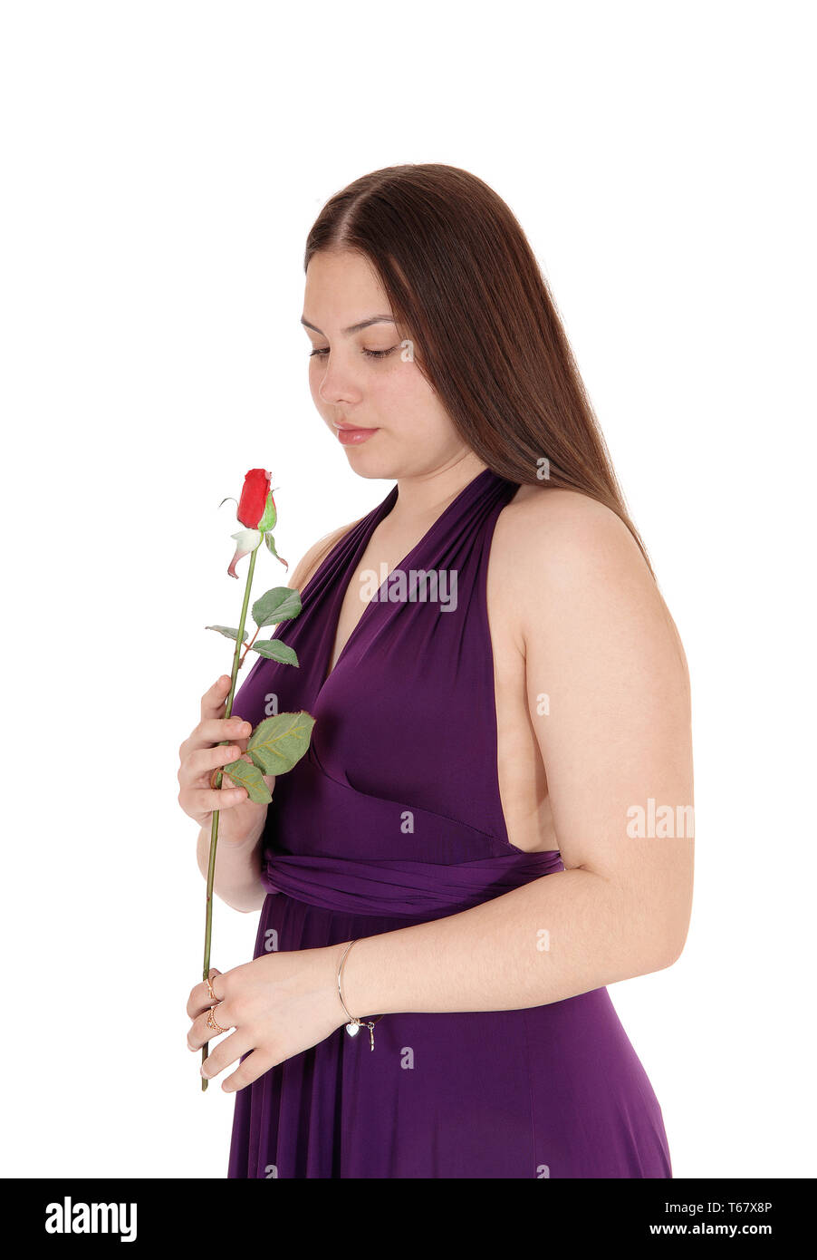 A beautiful young teenager girl standing in the studio in a burgundy ...