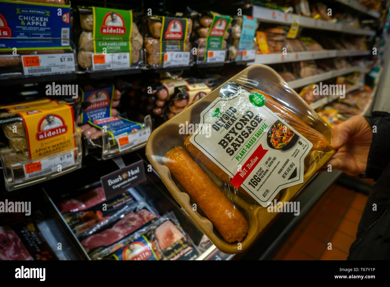 A shopper chooses a package of Beyond Meat brand Beyond Sausage from a cooler in a supermarket in New York on Monday, April 22, 2019. The plant-based protein start-up Beyond Meat has filed for an initial public offering and is expecting the share price to be between $19 and $21 valuing the company over $1 billion, well into the “unicorn” realm. (© Richard B. Levine) Stock Photo