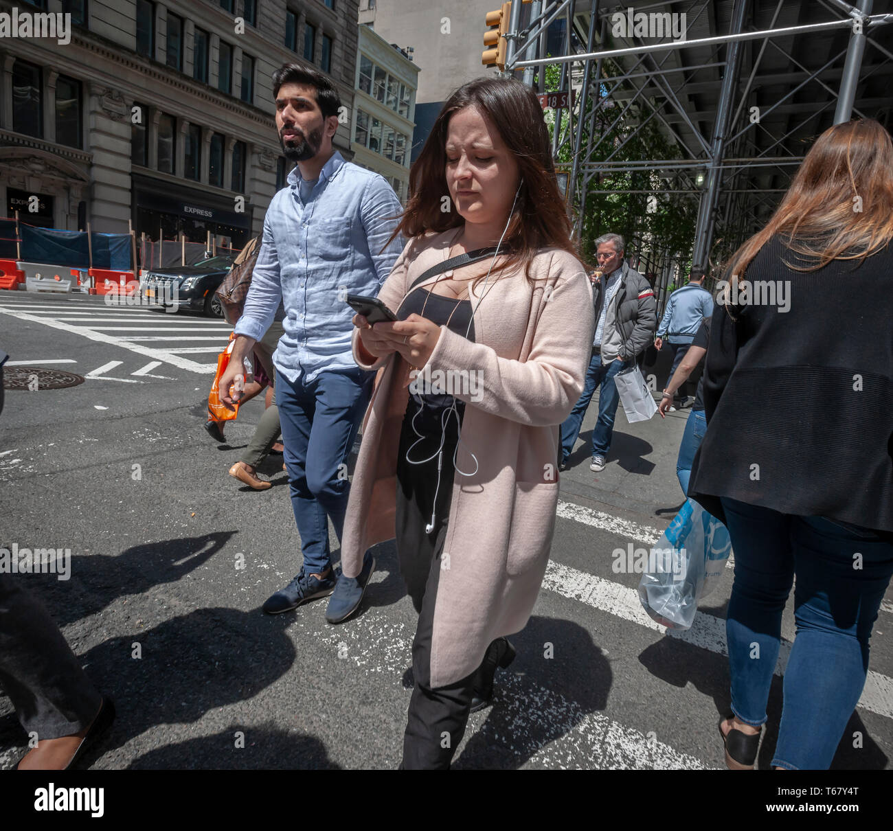 A distracted woman, engrossed in her smartphone, crosses the street in New York on Tuesday, April 23, 2019.  (Â© Richard B. Levine) Stock Photo