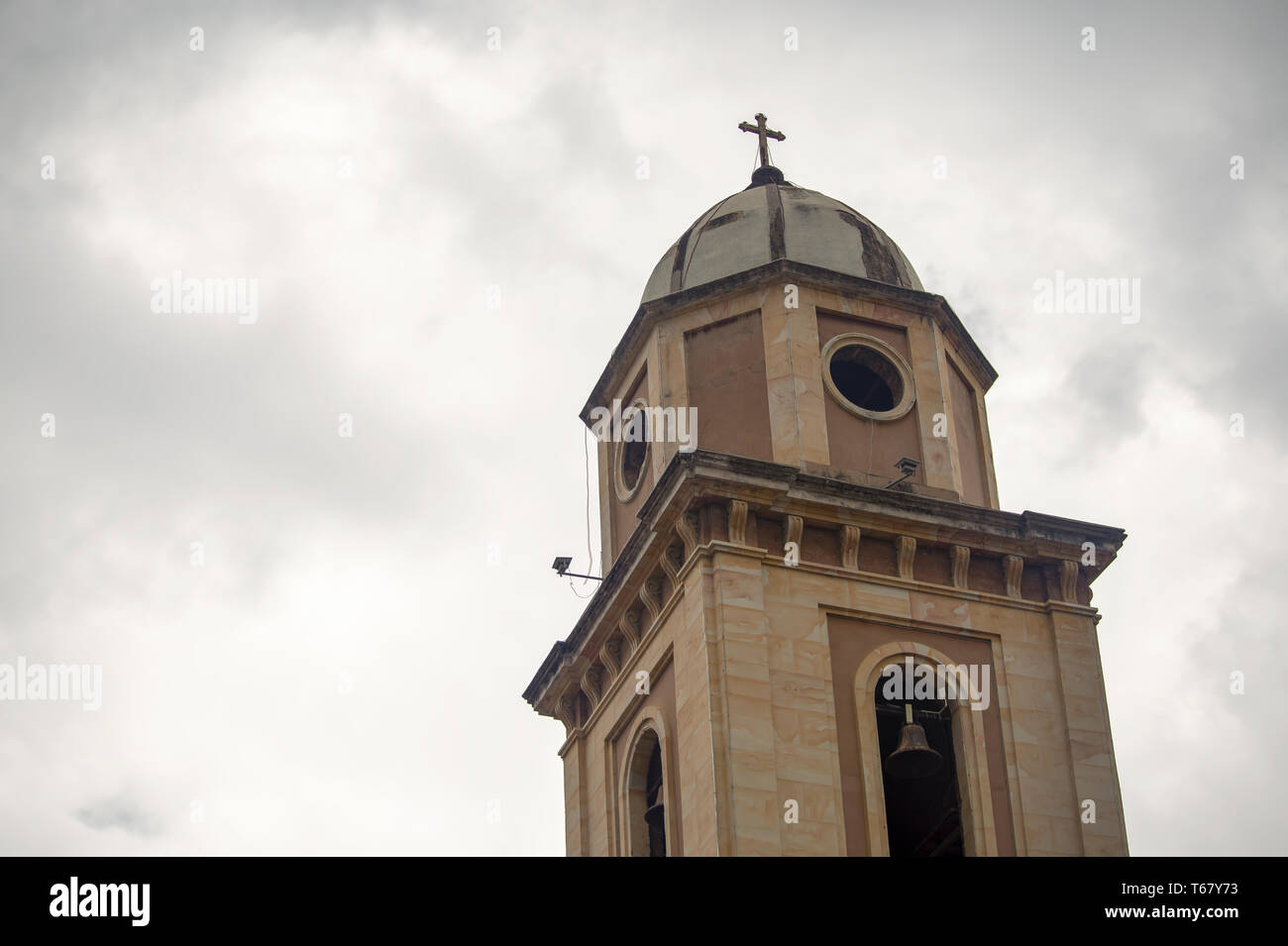 Bell tower of the colonial church of Iza, an old town in the Andean mountains of central Colombia, captured against the overcasted sky. Stock Photo