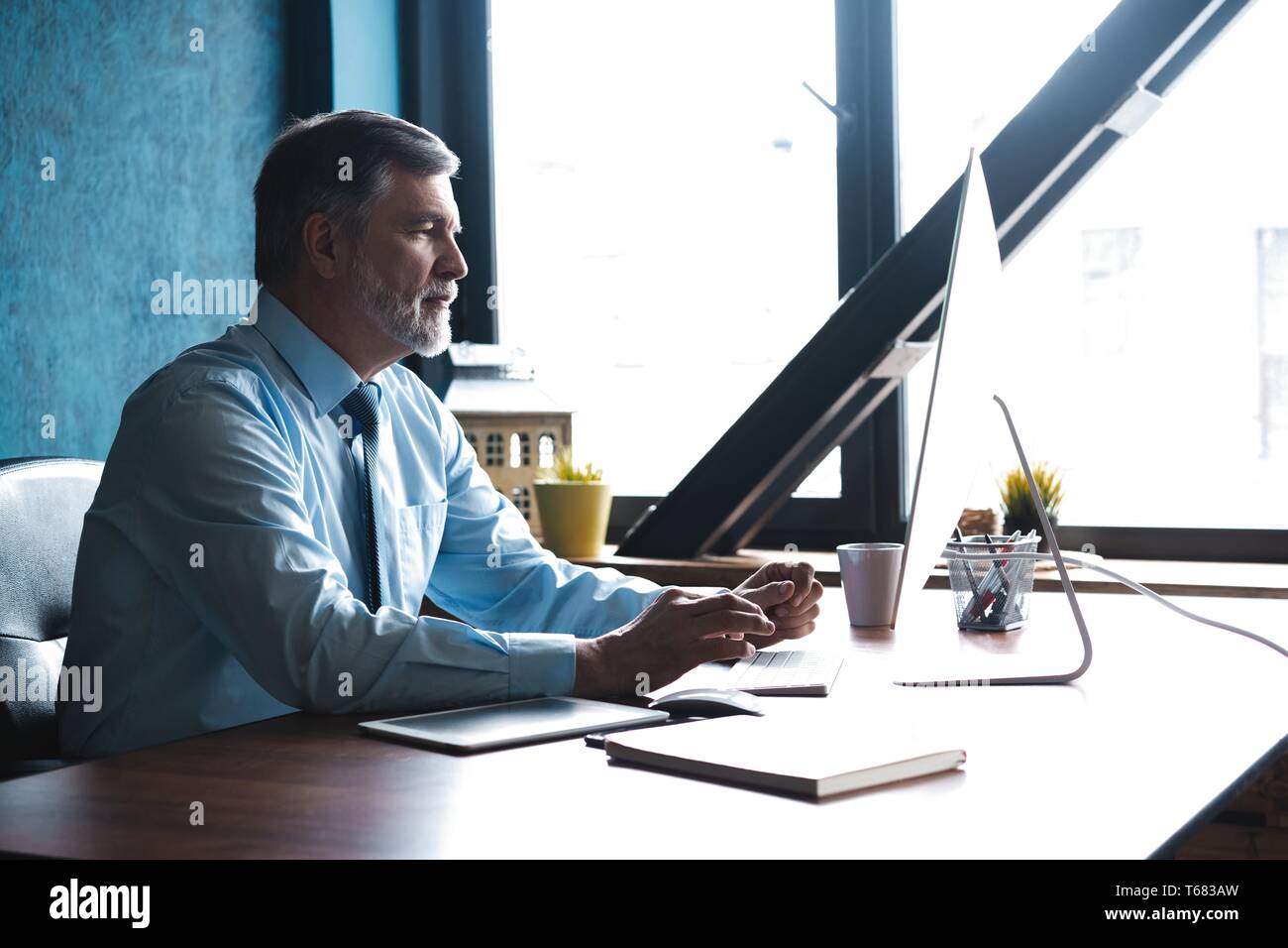 Mature Businessman Working On Computer In Modern Office Stock Photo - Alamy