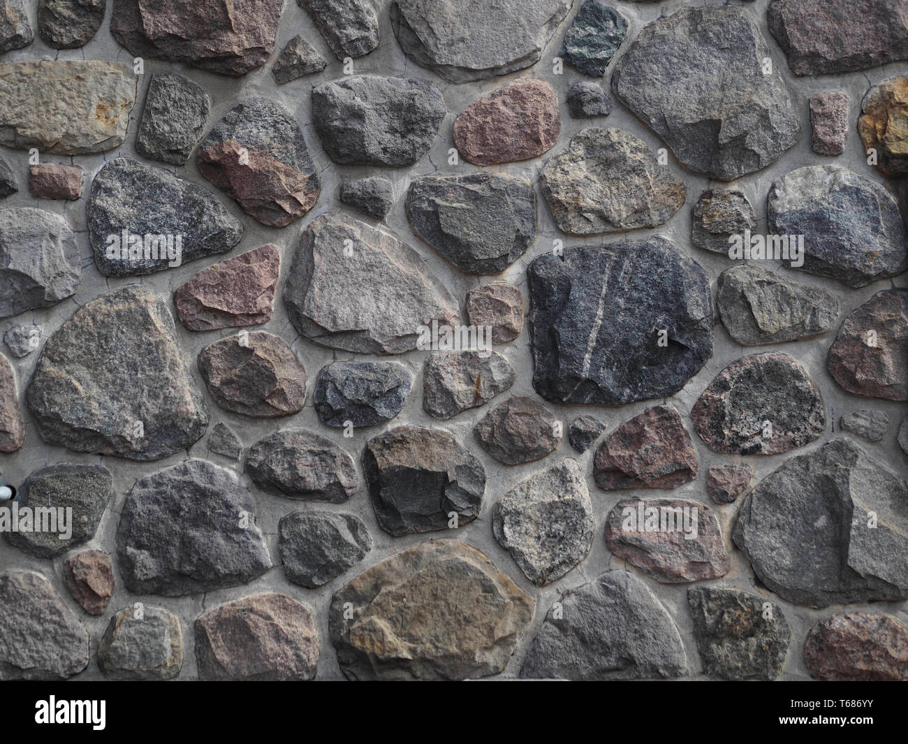 Natural stone masonry wall, made on rock stone, textured wall, background Stock Photo