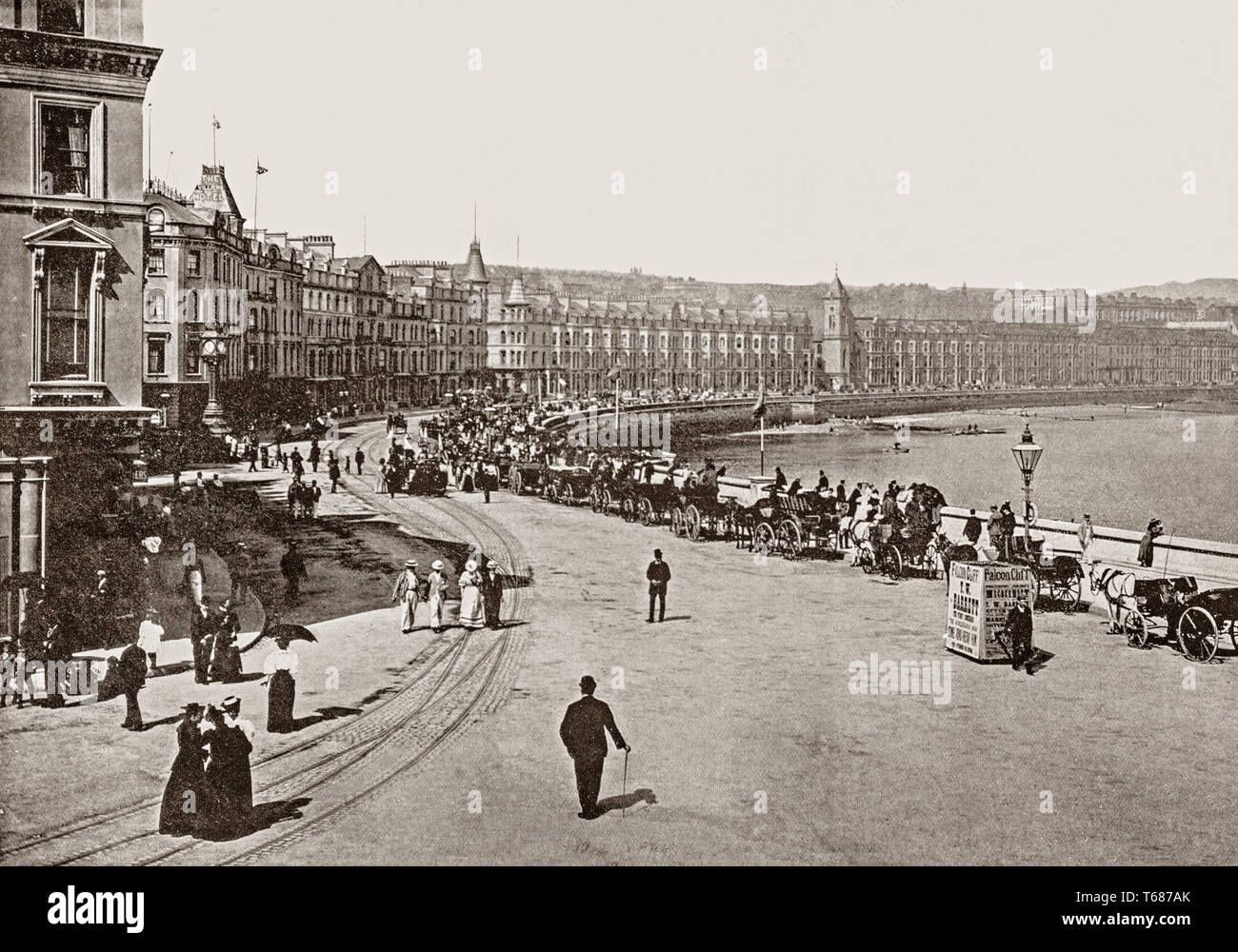 Late 19th Century views of  the busy Loch Promenade that runs nearly the entire length of beachfront in Douglas was constructed in 1878. Douglas is the capital, main commercial port and largest town of the Isle of Man,It grew rapidly as a result of links with the English port of Liverpool in the 18th century. It became a major tourist destination following the formation of the Isle of Man Steam Packet Company in 1830, which  led to greatly improved services, and also laid the foundations for growth in both cargo and tourist traffic. Stock Photo