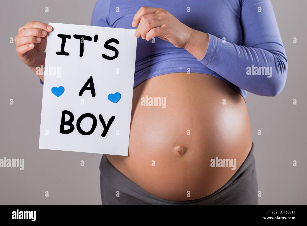 Image of close up stomach of pregnant woman holding paper with text it s a boy on gray background Stock Photo Alamy