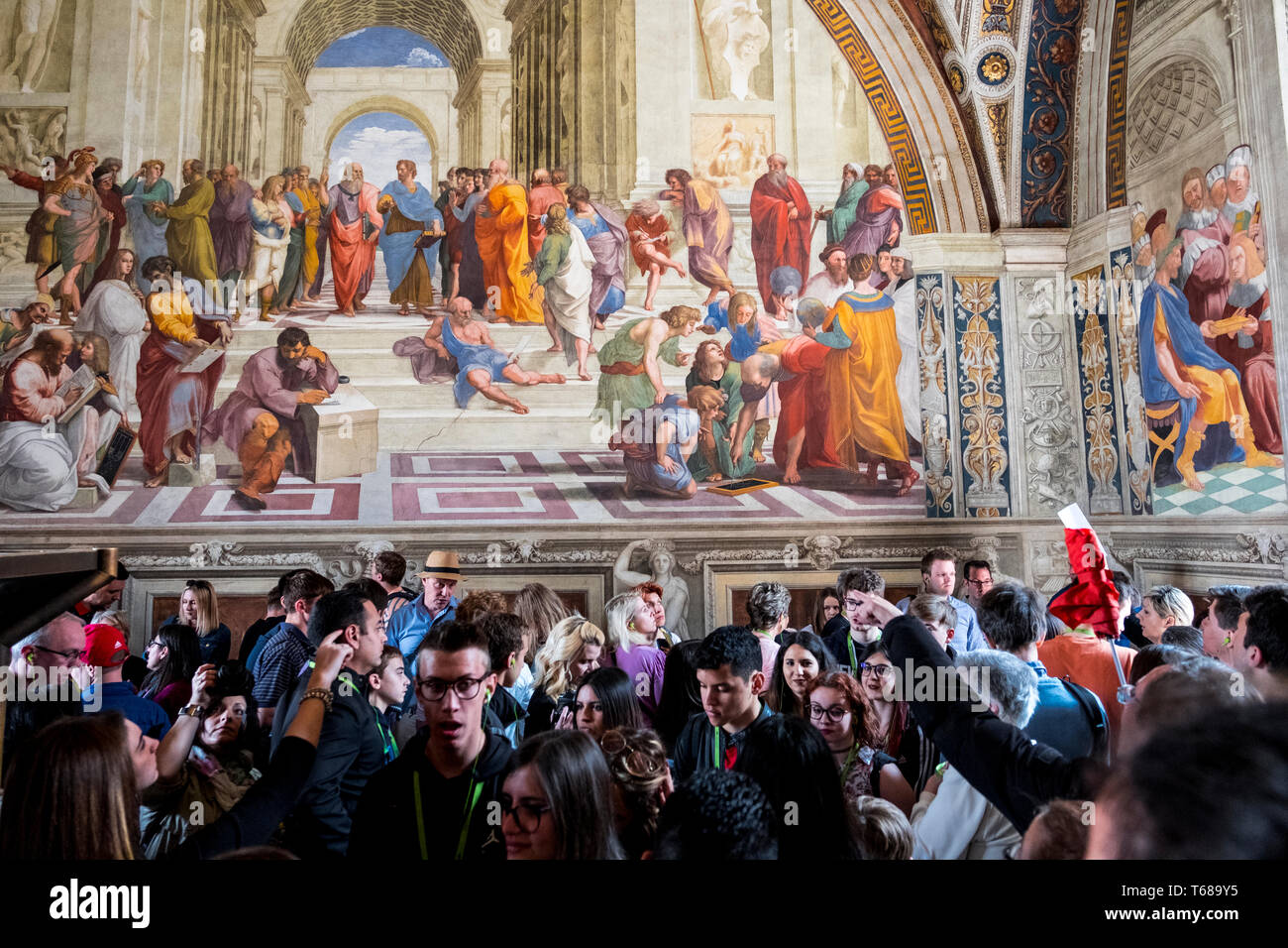 Tourists contemplate the School of Athens, painted by Raffaello Stock Photo