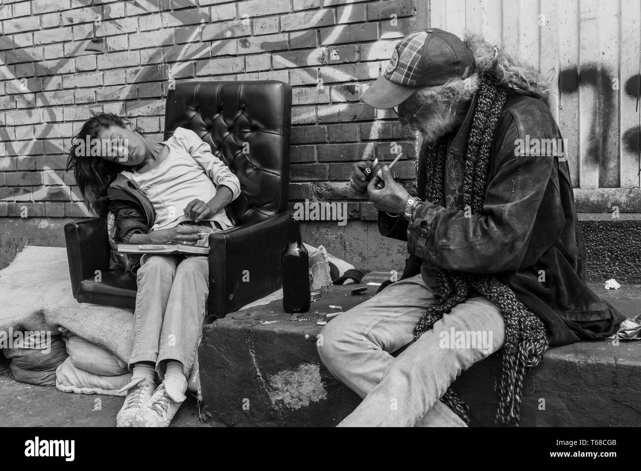 Woman and man smoke crack in the streets of Bogota, Colombia Stock Photo